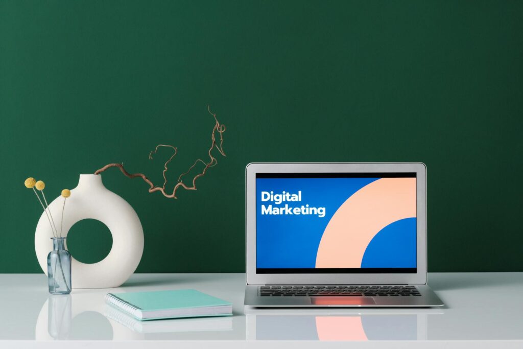 This image contains a laptop with a digital marketing image on it.